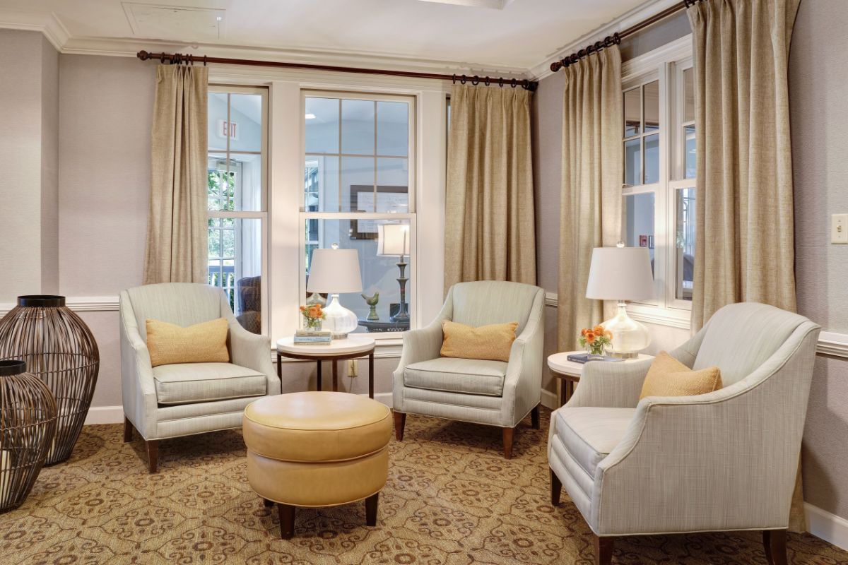 A cozy living room with armchairs, a round coffee table, and elegant lighting.