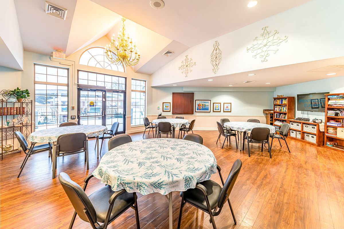 A well-lit community center meeting room with tables and chairs arranged for gatherings.