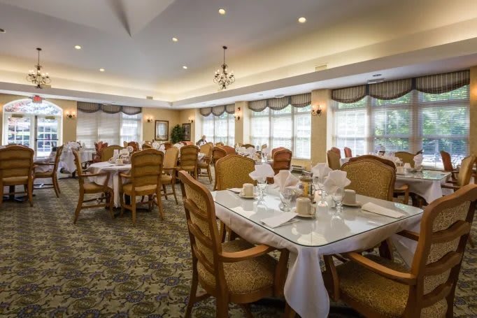 A spacious and elegantly decorated dining room with neatly arranged tables and chairs.