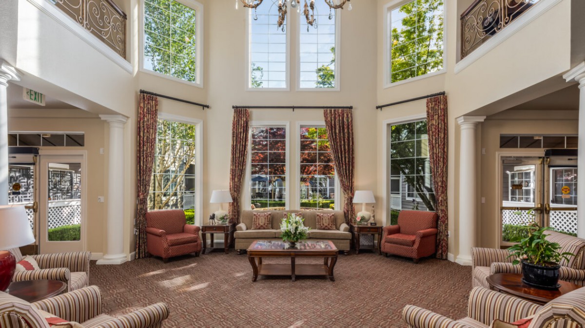 A cozy living room with large windows, stylish curtains, and comfortable seating.