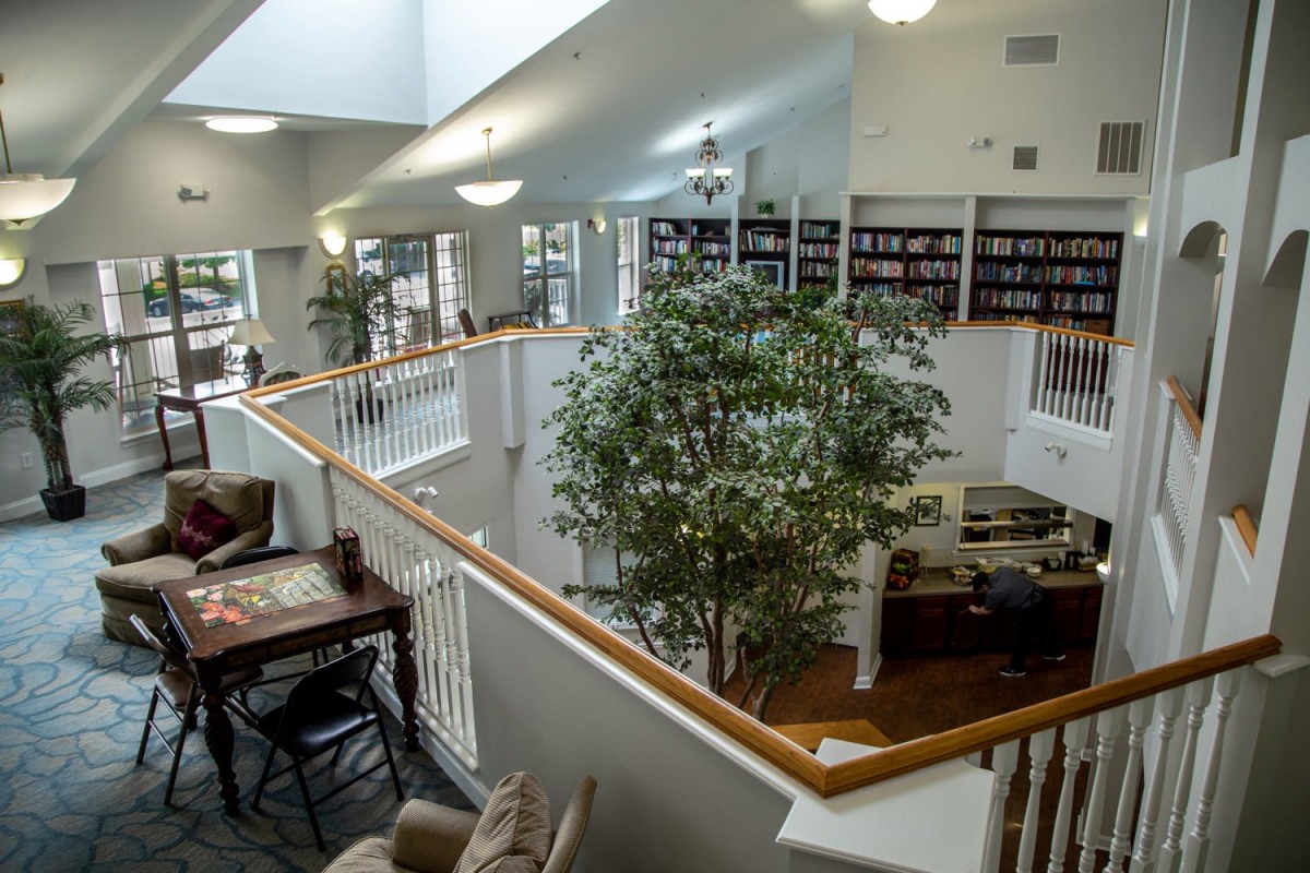 A cozy library space with bookshelves, comfortable seating, and natural lighting.