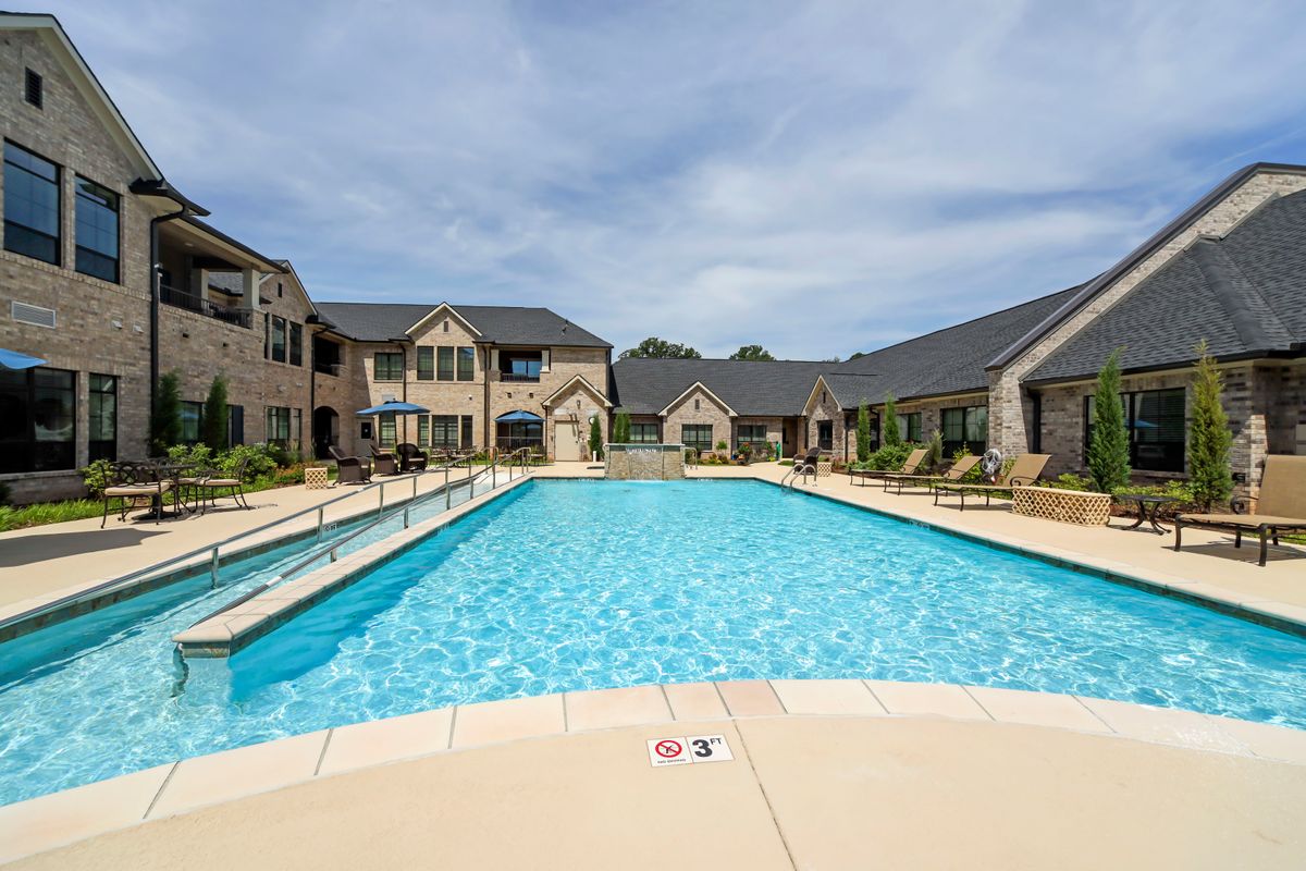 A serene view of a swimming pool in a residential apartment complex.