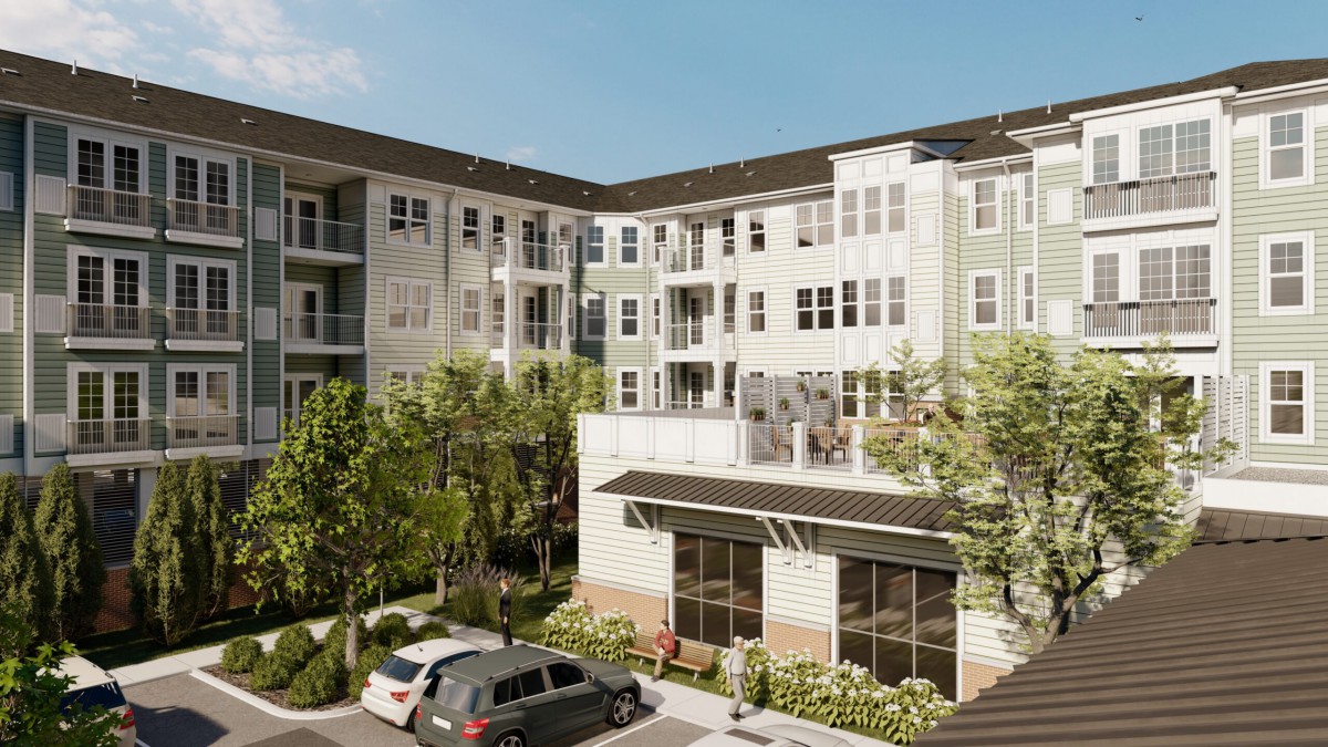 Modern apartment complex with landscaped surroundings and parked cars.