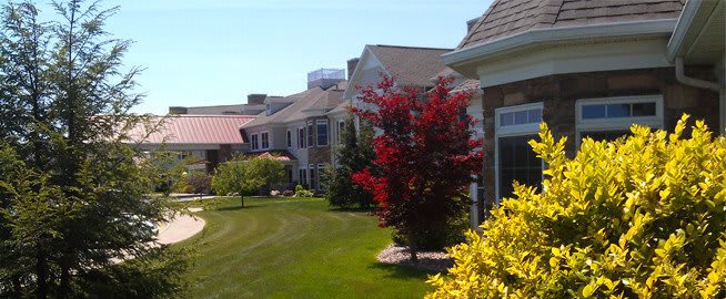 A suburban neighborhood with well-maintained lawns and colorful trees.