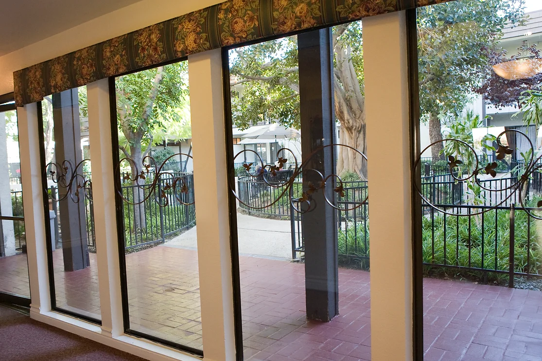 View through large windows overlooking a garden with a patio.