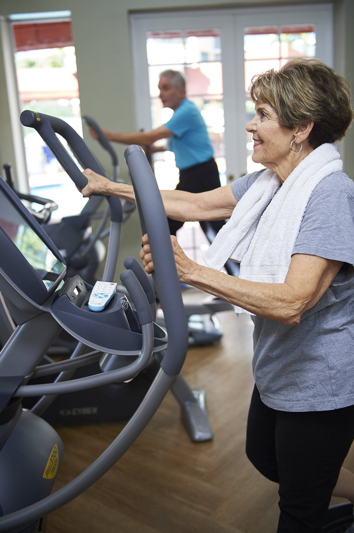 A senior woman exercises on a treadmill at the gym.