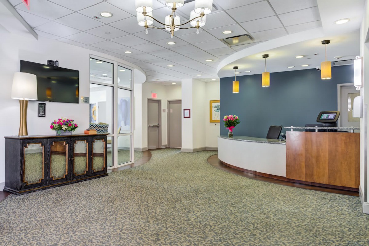 A modern office reception area with a front desk and waiting space.