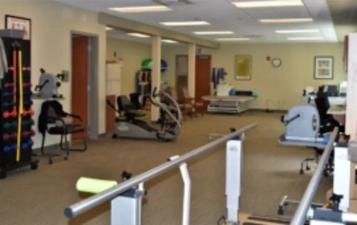 A rehabilitation and physical therapy room with various exercise equipment.