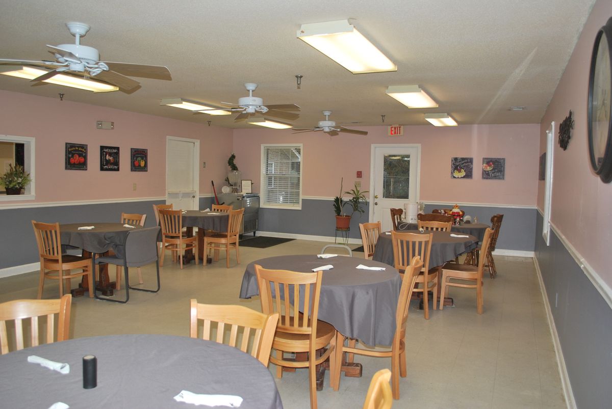 An empty restaurant interior with neatly arranged tables and chairs.