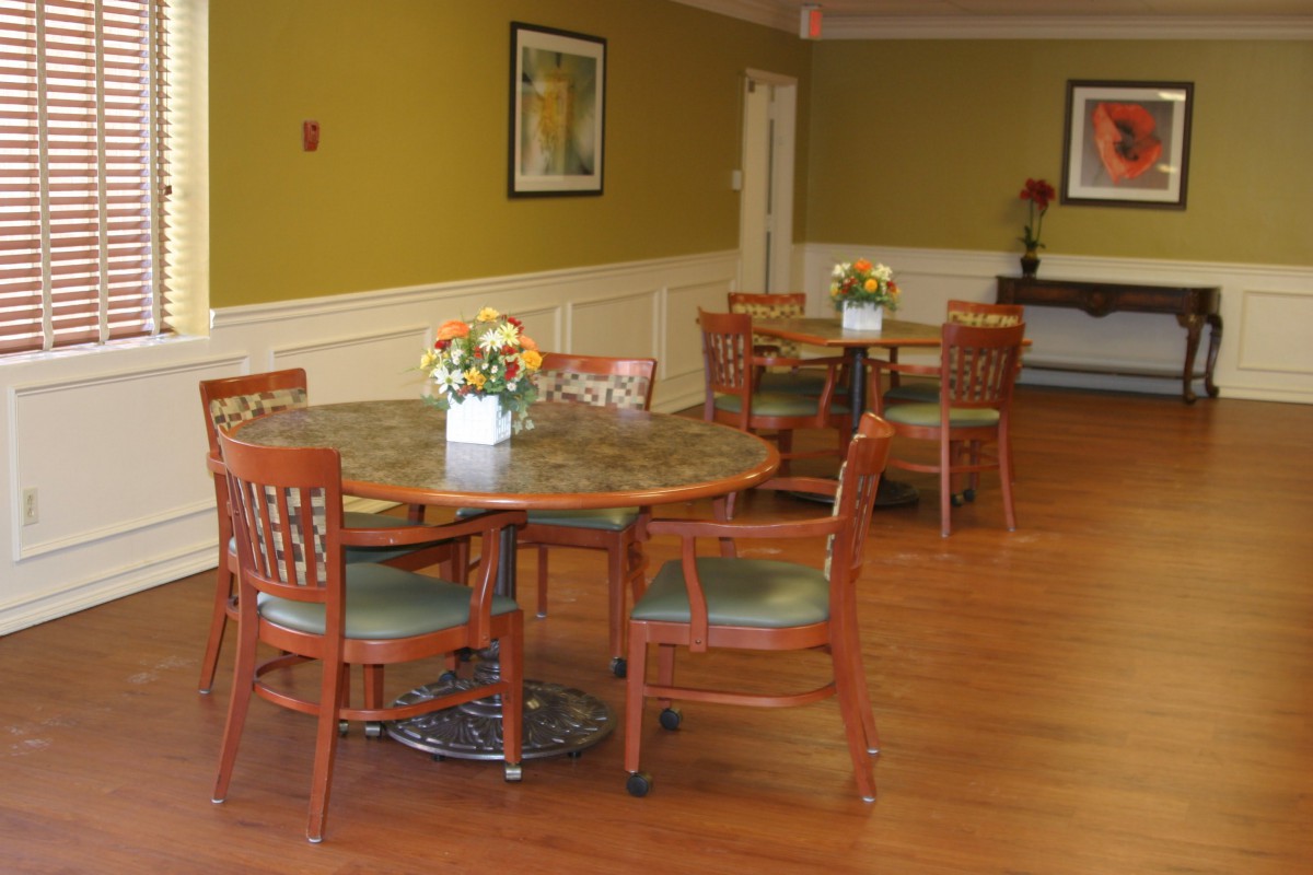 A cozy dining area with round tables and floral centerpieces.