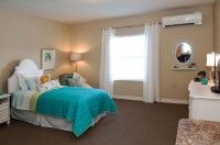A cozy bedroom with a teal bedspread and soft lighting.