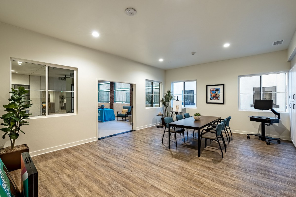 A modern dining room with wooden flooring and minimalist furniture.