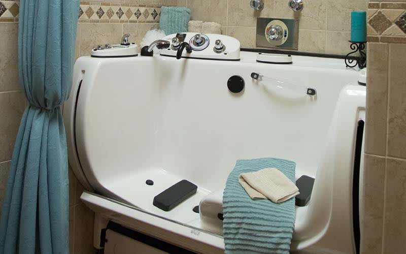 A bathroom featuring a specialized bathtub with towels placed on its edge.