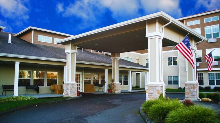 A building with a covered entryway supported by columns.