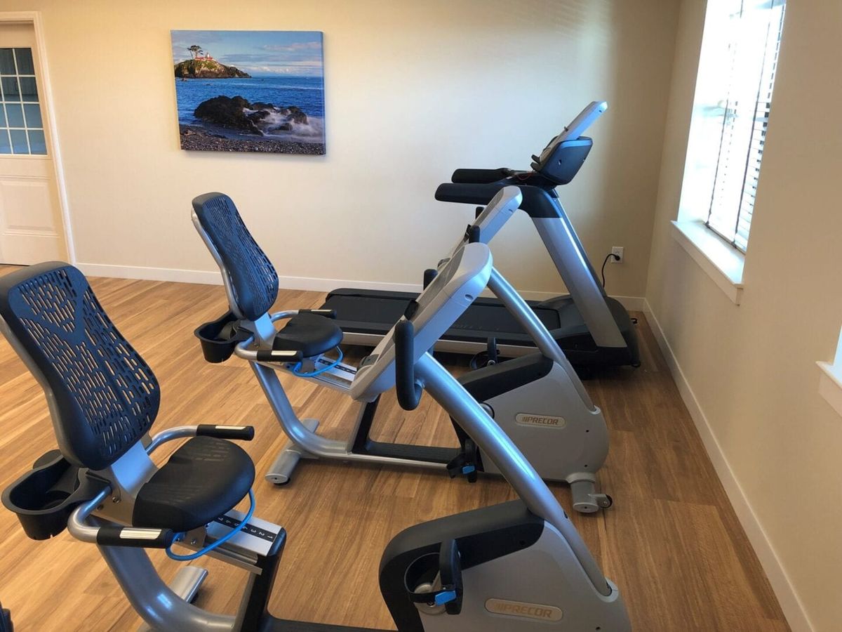 A small gym with exercise equipment including a treadmill and stationary bike.