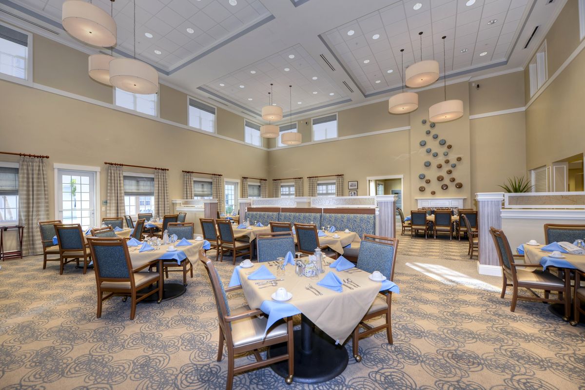 A spacious and elegantly decorated dining area with neatly arranged tables and modern lighting fixtures.