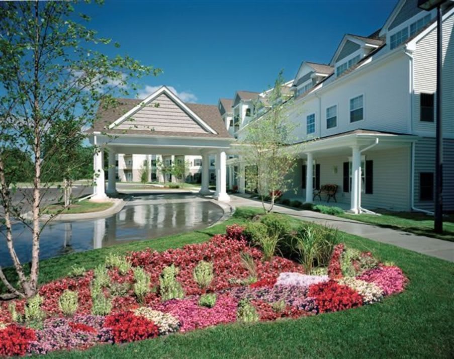 A beautiful garden with vibrant flowers in front of a large residential building.