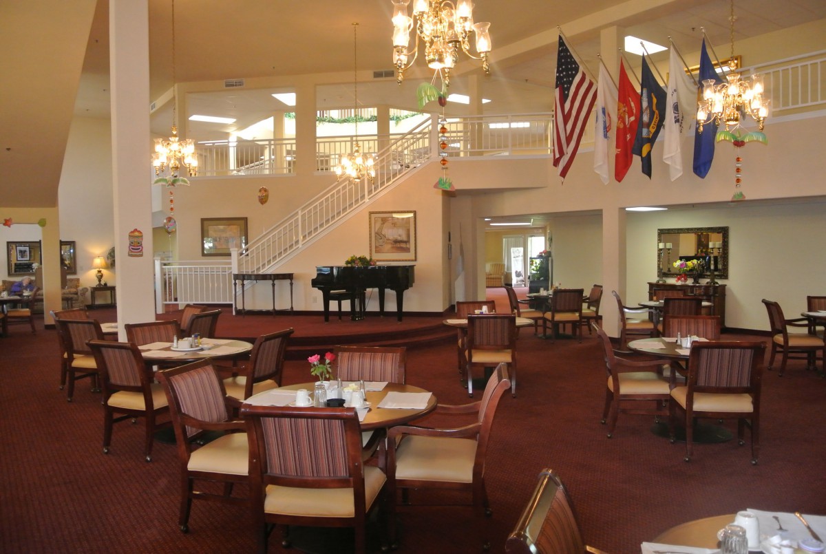 Elegant dining area with a grand piano and flags on display.