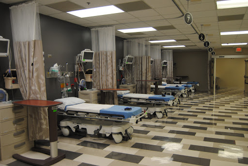 An empty medical treatment area with patient beds in a hospital setting.