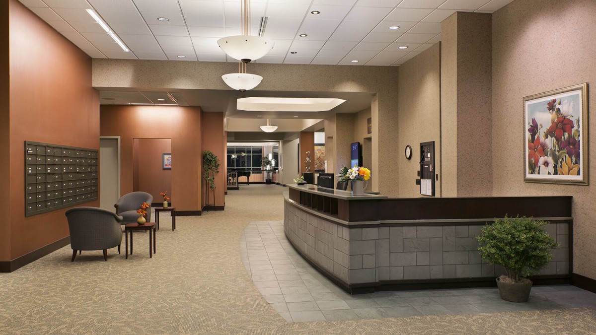 A modern, spacious lobby with a reception desk and seating area.
