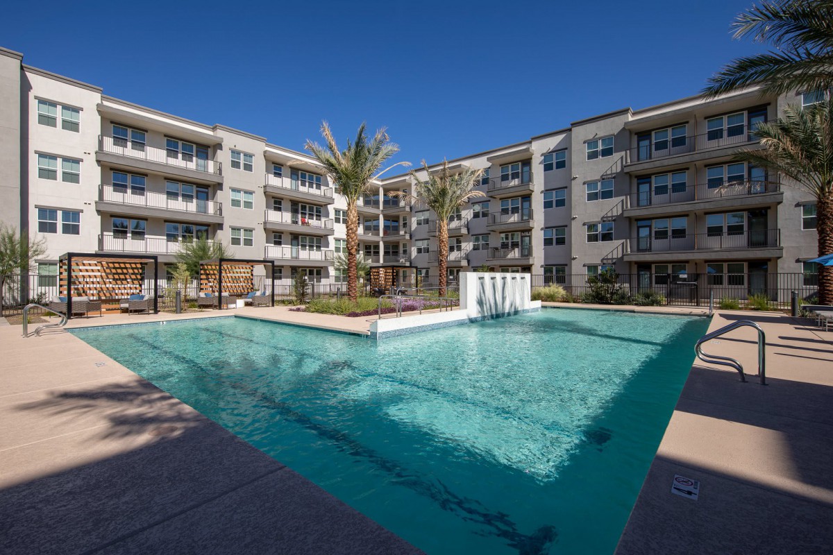 A modern apartment complex featuring a central swimming pool and courtyard.