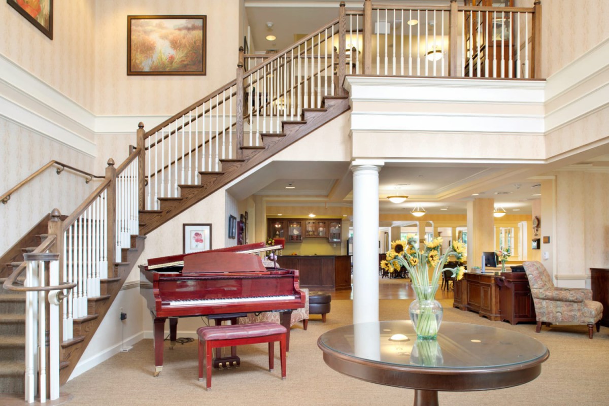 A spacious lobby with a grand piano and elegant staircase.