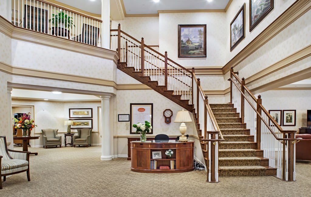 A spacious lobby with a staircase and a reception desk.