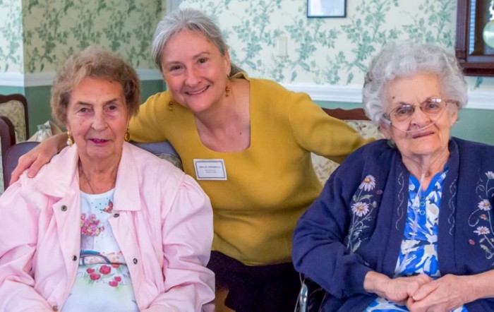 A group of seniors posing together and smiling indoors.