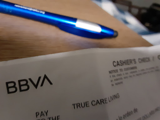 A close-up of a bank receipt with a pen resting on it.