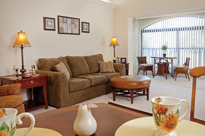 A cozy living room with a brown sofa, coffee table, and warm lighting.
