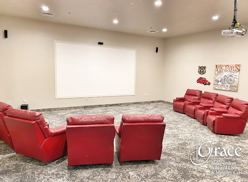 A cozy home theater setup with red recliners facing a large projection screen.