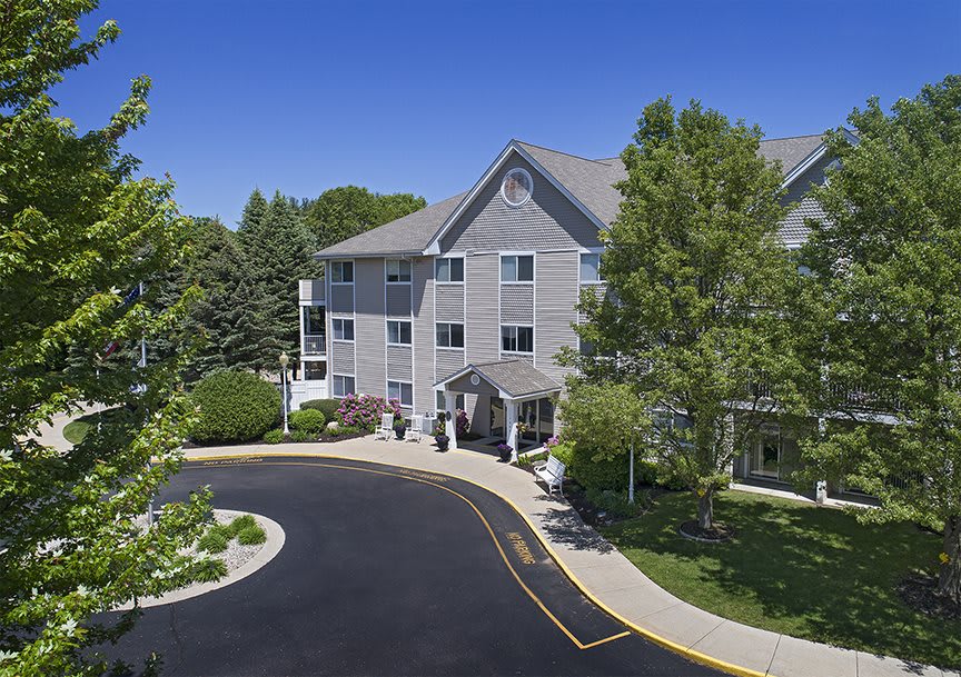 A hotel surrounded by lush greenery with a clear blue sky.