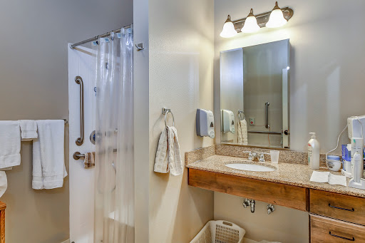 A modern bathroom featuring a shower, sink, and well-lit vanity.