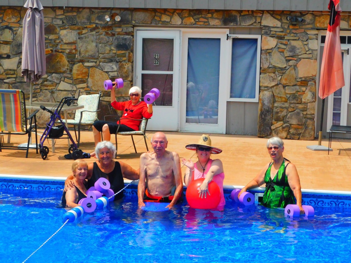 A group of seniors enjoying water aerobics by the pool.