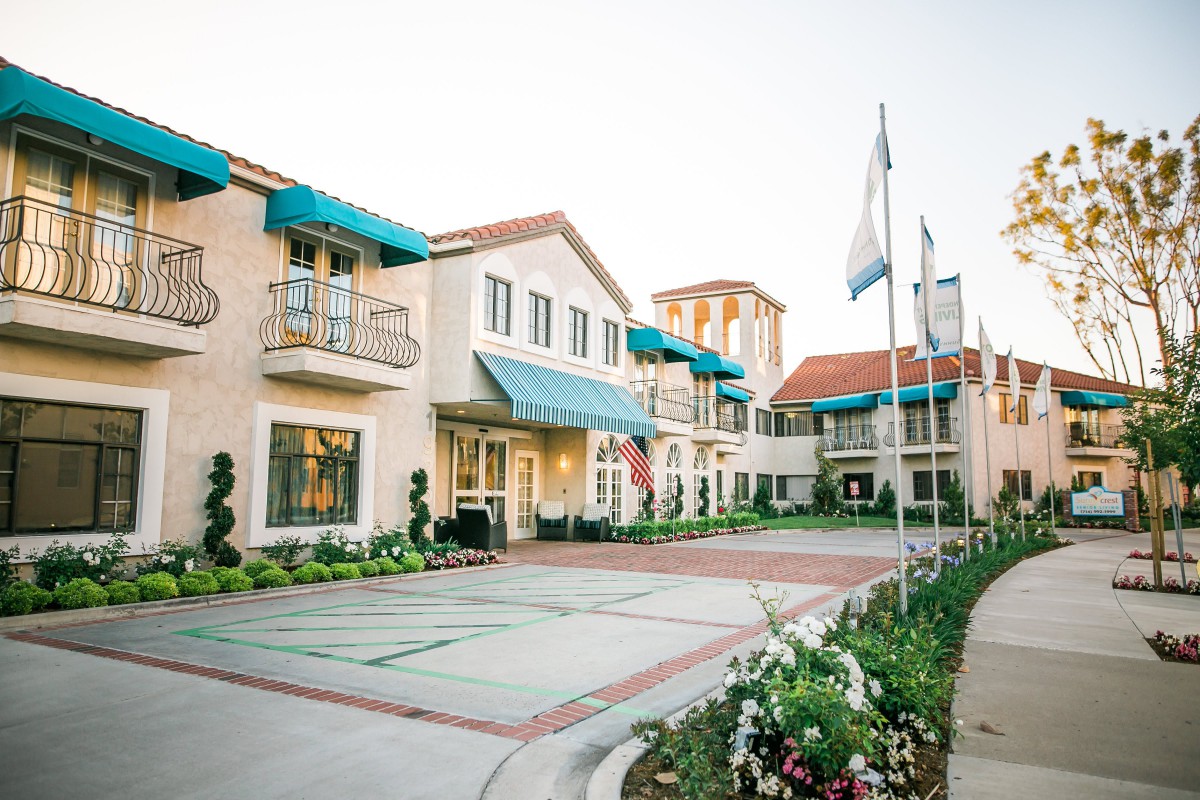 A charming building with blue awnings and flags out front, surrounded by well-maintained landscaping.