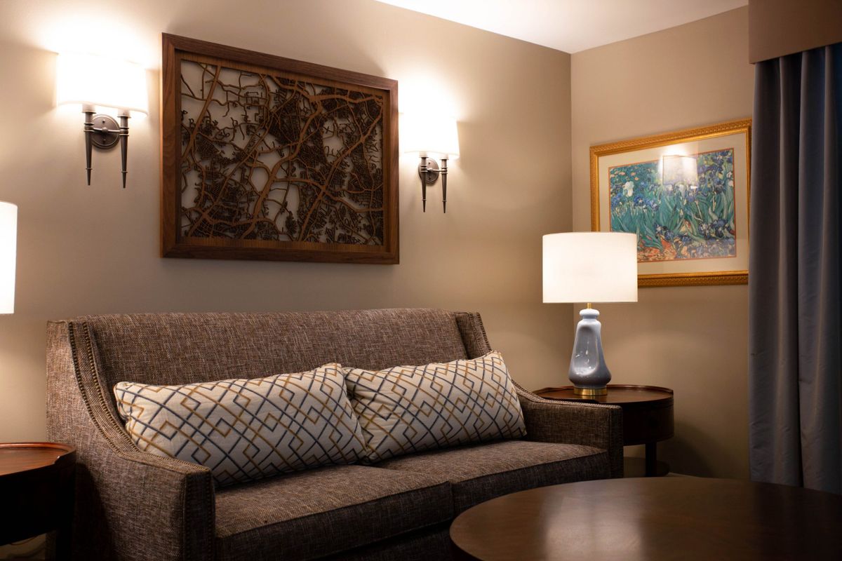 A cozy living room with a comfortable sofa, decorative pillows, and ambient lighting from a table lamp.