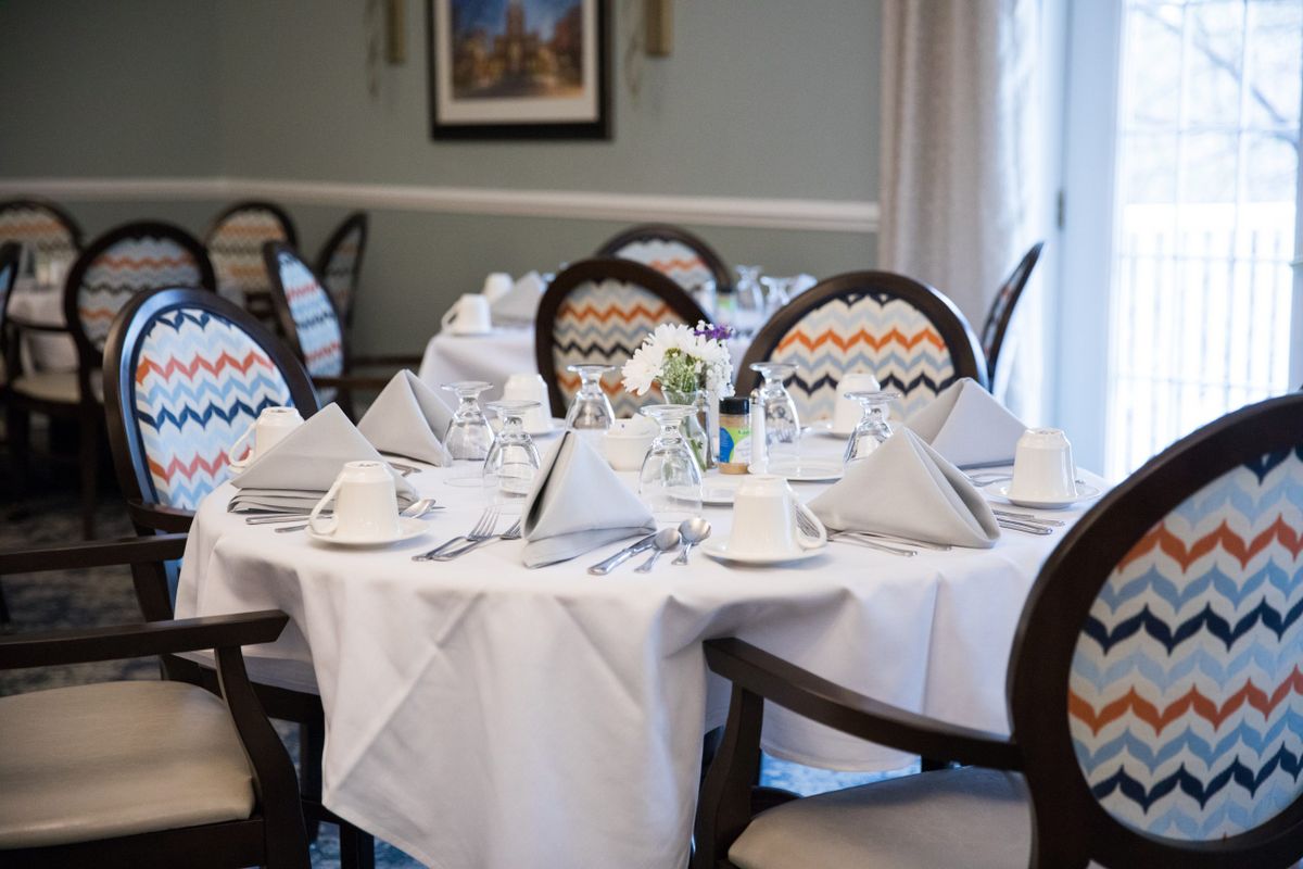 An elegantly set dining table in a restaurant, complete with napkins and cutlery.