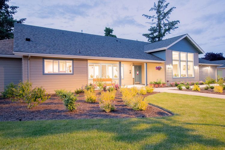 A well-maintained suburban house with a landscaped front yard during the evening.