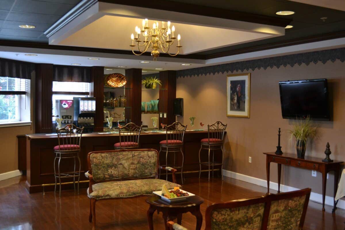 A cozy bar lounge with elegant seating and a chandelier.
