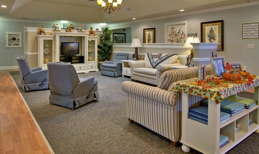 A cozy living room featuring comfortable sofas, armchairs, and a television set.