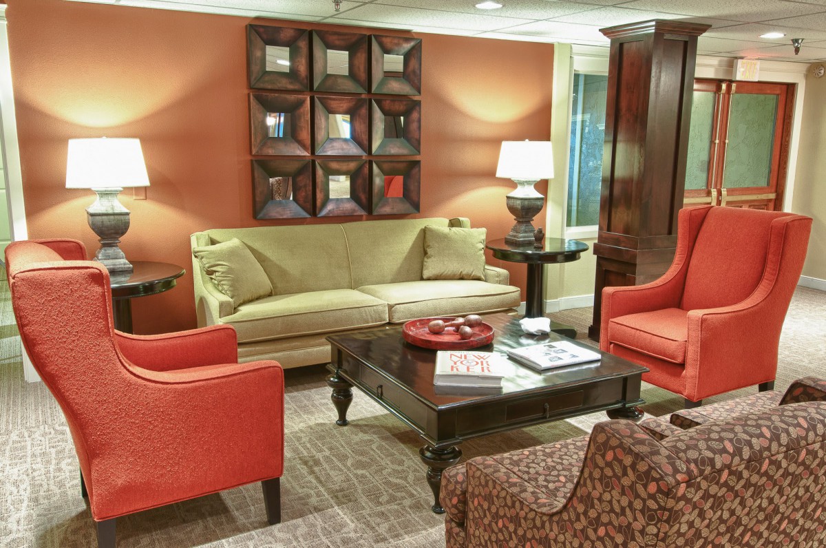 A cozy living room with a mix of furniture and warm lighting.
