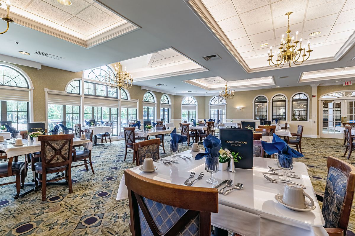 An elegant dining area with chandeliers and large windows, offering a bright and inviting atmosphere.