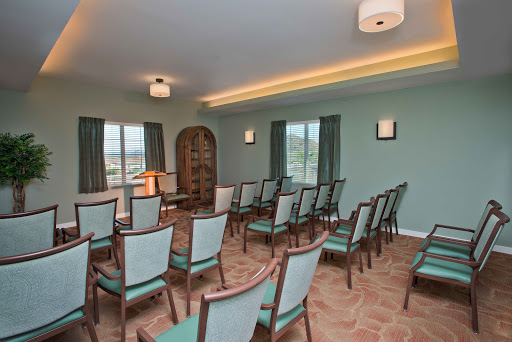 A spacious waiting area with neatly arranged chairs and calming green walls.