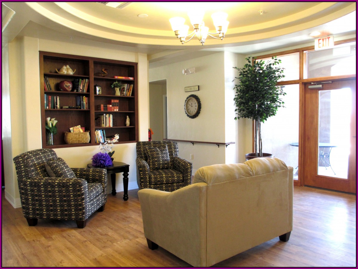A cozy seating area featuring a bookshelf, comfortable chairs, and a sofa with soft lighting.