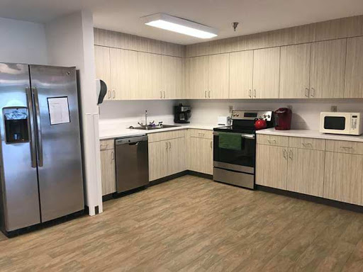A modern kitchen featuring light-colored cabinets and essential appliances.