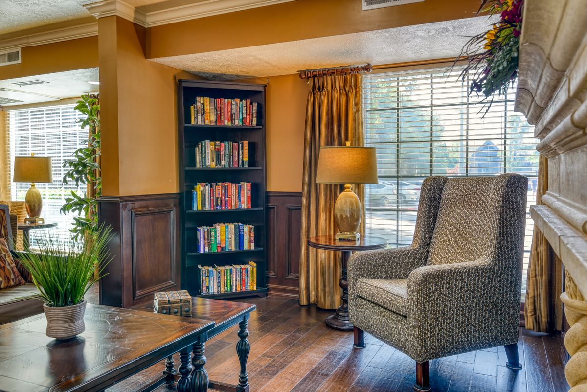 Cozy living room with a bookshelf and comfortable armchair by the window.