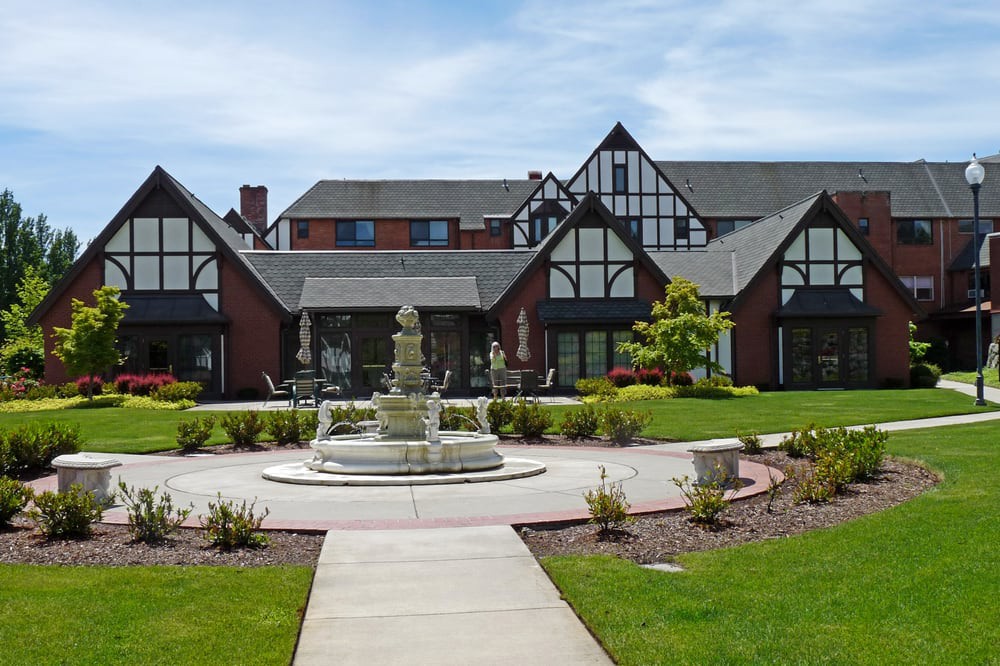 A Tudor-style building with a central fountain and landscaped gardens.