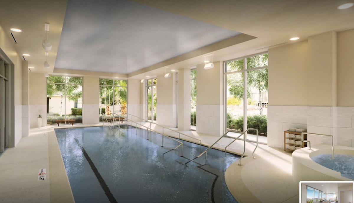 A luxurious indoor swimming pool with large windows allowing natural light to flood in.