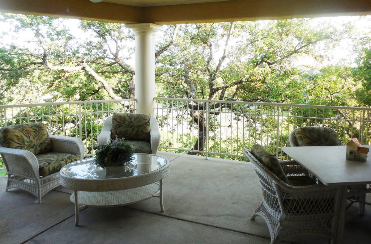 A cozy patio with comfortable seating and a view of lush greenery.