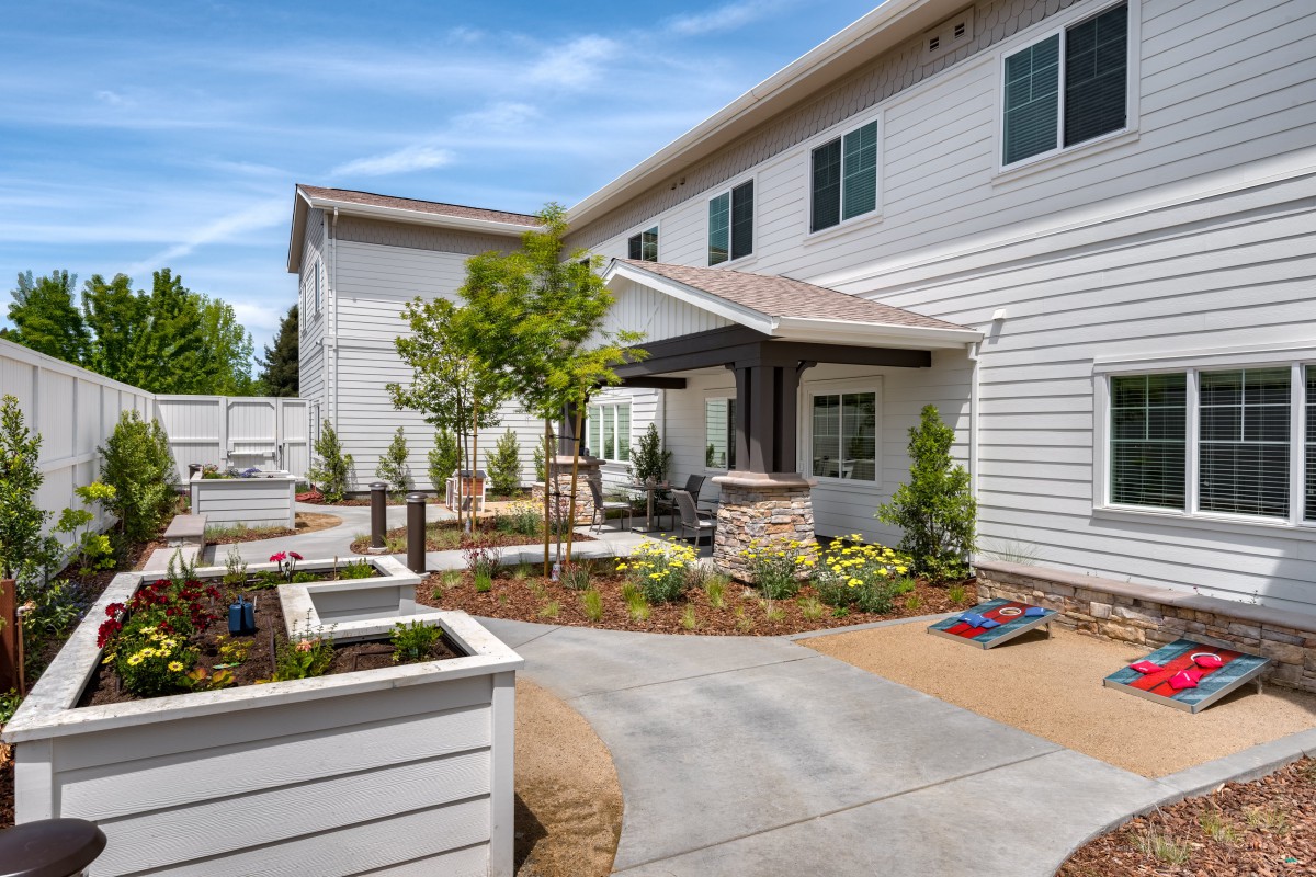 A well-landscaped residential outdoor patio area with a paved walkway and garden.